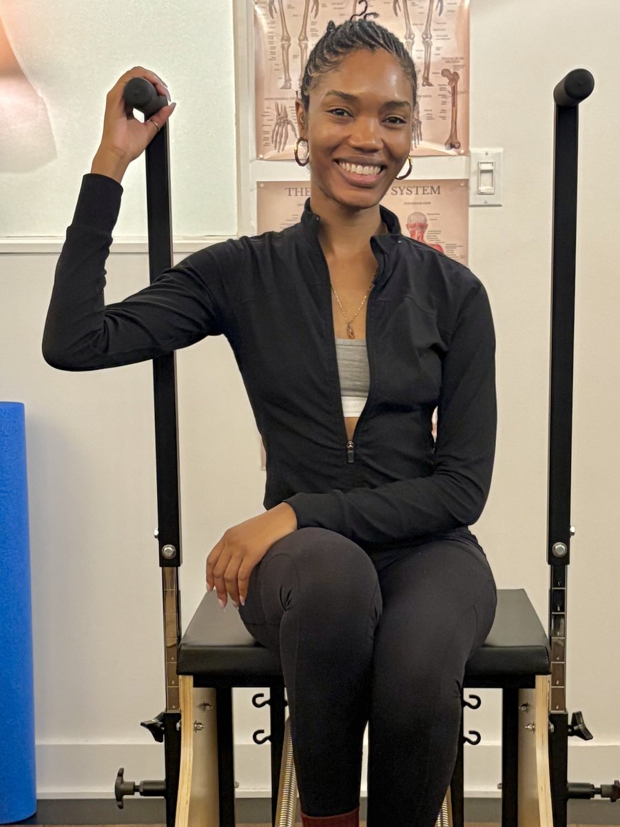 Ruqayyah seated on the Stability Chair in her studio, smiling towards the camera